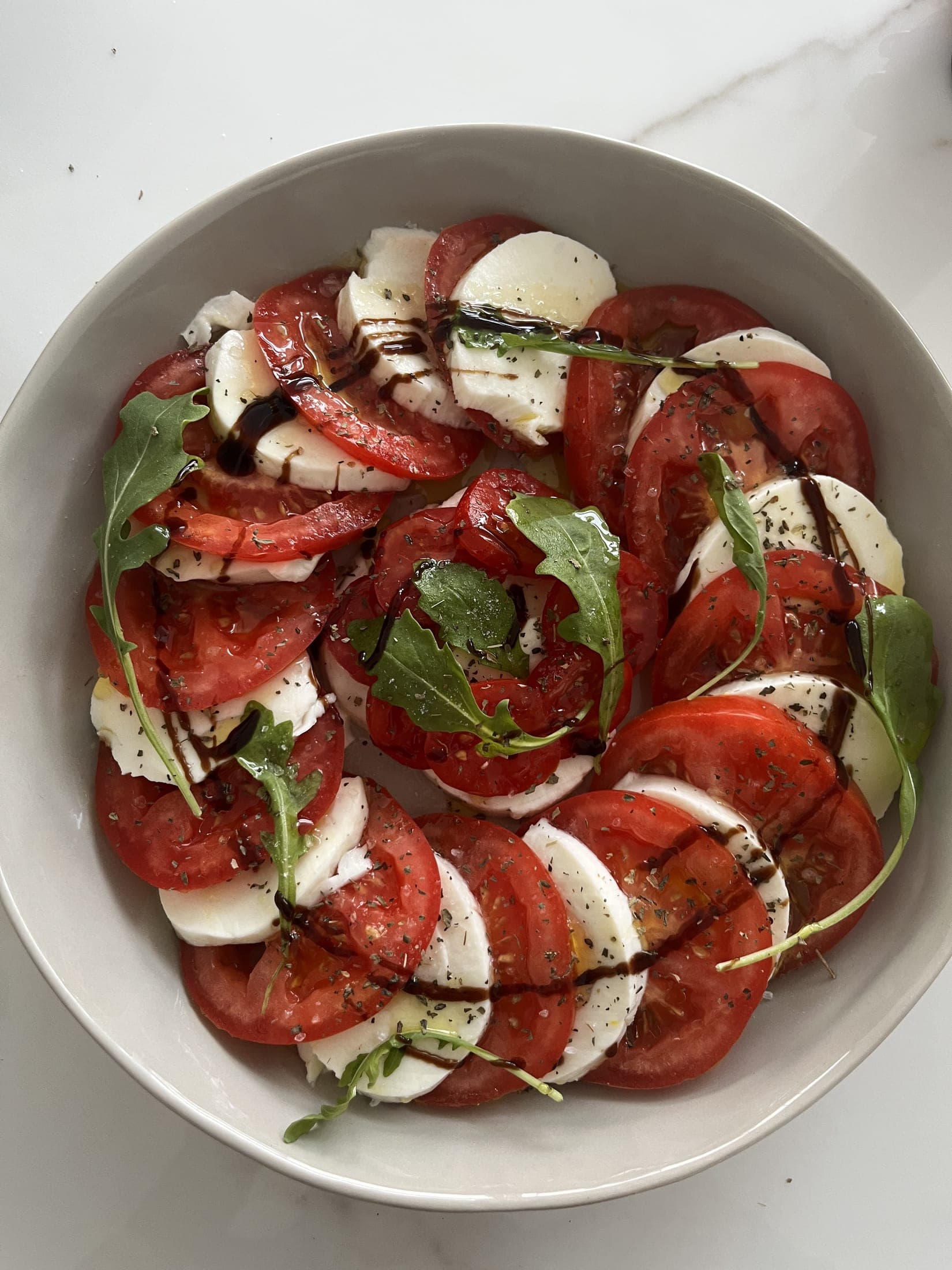 Bowl saludable de caprese con rúcula y balsámico