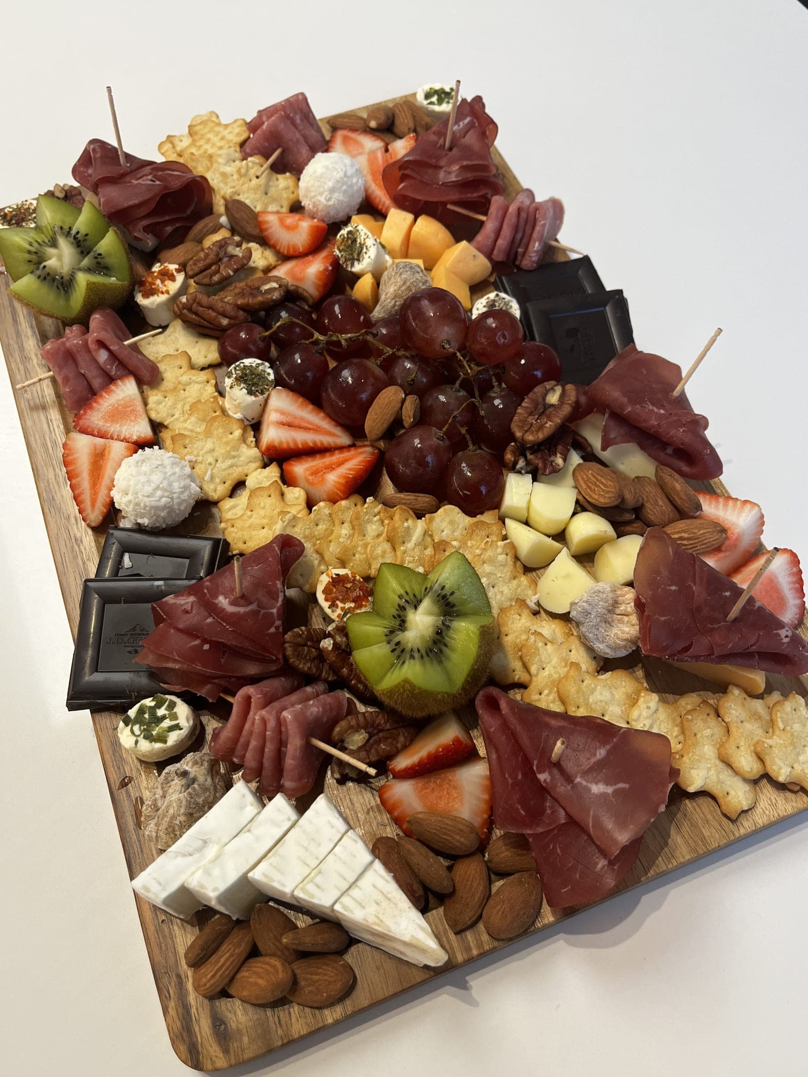 Tabla colorida de fruta, frutos secos y chocolate
